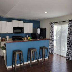 a kitchen with three bar stools and a blue wall at Private 1 BDR with Free Parking, Just 5 Minutes from Downtown in Indianapolis