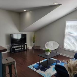 a living room with a couch and a tv at Private 1 BDR with Free Parking, Just 5 Minutes from Downtown in Indianapolis