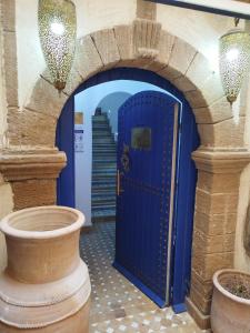 an archway with a blue door in a building at RIAD MAROSKO in Essaouira