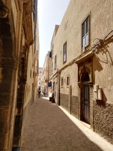 an empty street in an alley between two buildings at RIAD MAROSKO in Essaouira