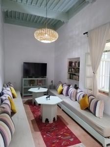 a living room with a couch and a tv at RIAD MAROSKO in Essaouira