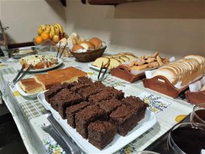 a table topped with different types of bread and desserts at Pousada Bella Serra in Canela