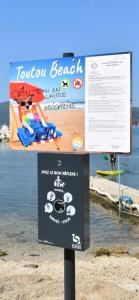 a sign in front of a body of water at Studio le Monroe les pieds dans l'eau 10 m de la mer in La Seyne-sur-Mer