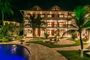 a large house with a pool in front of it at Windtown Beach Hotel in Cumbuco
