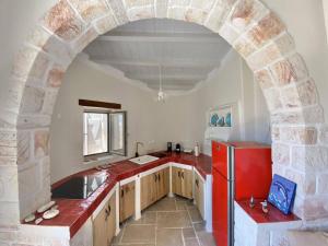 an archway in a kitchen with a red refrigerator at Fournos in Kimolos