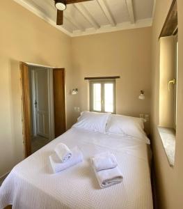 ein Schlafzimmer mit einem weißen Bett und Handtüchern darauf in der Unterkunft Fournos in Kimolos