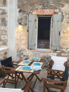 a patio with a table and chairs and a window at Fournos in Kimolos