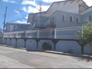 a white building with a white balcony on the side of it at Vilarejo da Esperanza in Campos do Jordão
