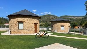 una bicicleta estacionada en el césped frente a un edificio en Pallozas Turisticas Ridicodias - A Pedra, 