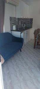 uma sala de estar com um sofá azul e uma mesa em Tower apartment em Sukošan