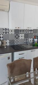 uma cozinha com azulejos pretos e brancos na parede em Tower apartment em Sukošan