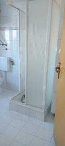 ein weißes Bad mit einer Dusche und einem WC in der Unterkunft Tower apartment in Sukošan