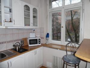 cocina con armarios blancos y microondas en Old Riga - Kalku apartment, en Riga