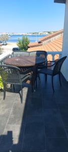 einen Tisch und Stühle auf einem Balkon mit Meerblick in der Unterkunft Tower apartment in Sukošan