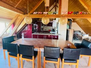 a dining room with a large wooden table and chairs at Bed-International in Roggwil