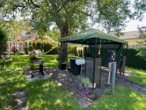 a green gazebo with a table in a yard at Bed-International in Roggwil