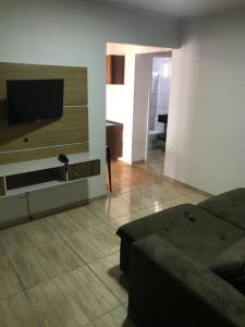 een woonkamer met een bank en een flatscreen-tv bij Casa com 2 quartos agradáveis com ar condicionado in Foz do Iguaçu