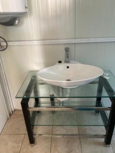 um lavatório numa mesa de vidro na casa de banho em Синеморец Каравана Paradise em Sinemorets
