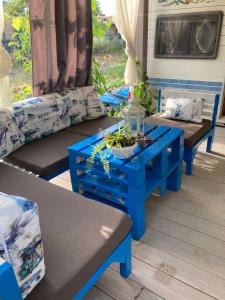 Синеморец Каравана Paradise في سينيموريتس: غرفة معيشة مع طاولات وأرائك زرقاء