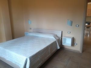 um pequeno quarto com uma cama num quarto em Appartament Noemi em Ricadi