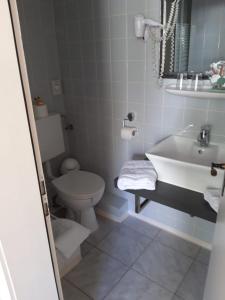 uma casa de banho com um lavatório branco e um WC. em Hotel zur Altstadt em Celle