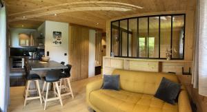 ein Wohnzimmer und eine Küche mit einem gelben Sofa und einem Tisch in der Unterkunft Marmotte du Jaillet Cosy and charmant appartement in Demi-Quartier