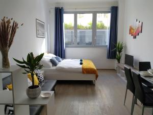 VIT Apartment - Free Parking - O2 Arena في براغ: غرفة نوم بسرير ومكتب ونافذة