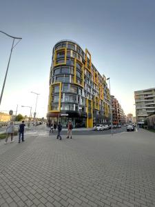 a tall yellow building with people walking in front of it at VIT Apartment - Free Parking - O2 Arena in Prague