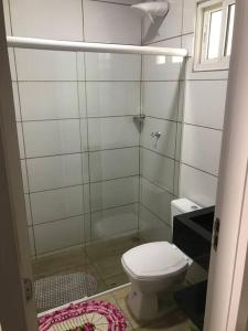 een kleine badkamer met een toilet en een douche bij Casa com 2 quartos agradáveis com ar condicionado in Foz do Iguaçu