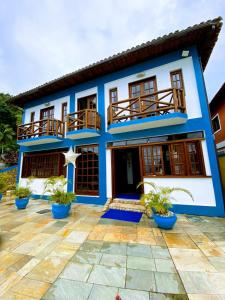 a blue and white house with potted plants at Pousada do Canto in Abraão