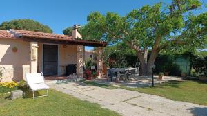 ein Haus mit einem Tisch und Stühlen im Hof in der Unterkunft CASA IL PINO in Orbetello