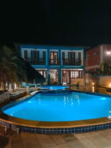 a swimming pool in front of a house at night at Pousada do Canto in Abraão