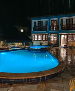 a swimming pool in front of a building at night at Pousada do Canto in Abraão