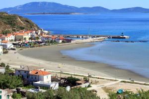 a beach with a town and a pier in the water at Rooms with WiFi Susak, Losinj - 18208 in Susak