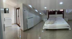 Un dormitorio con una cama blanca y una escalera en Casa vacanze rosario, en Vena Superiore