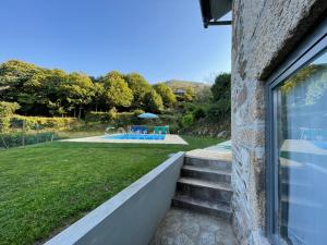 een uitzicht vanuit het raam van een huis met een zwembad bij Recantos da Montanha in Candal