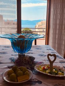 einen Tisch mit einer Schüssel Essen und einem Obstteller in der Unterkunft VISTAMARE apartments Reggio Calabria in Reggio di Calabria