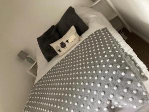 a bed with a comforter and pillows on it at Cragside Cottage in Troutbeck