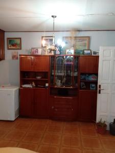 a kitchen with wooden cabinets and a room with a door at Ushuaia de las Nieves B&B in Ushuaia