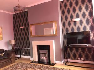 a living room with a fireplace and a mirror at Charming 1-Bed City Centre Apartment in Edinburgh in Edinburgh