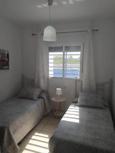 a bedroom with two twin beds and a window at Casa Enrique in Cádiz