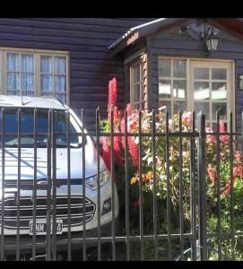 un coche aparcado frente a una casa con una valla en Ushuaia de las Nieves B&B en Ushuaia