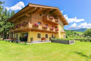 a house with a balcony with flowers on it at Haus Eder in Saalfelden am Steinernen Meer