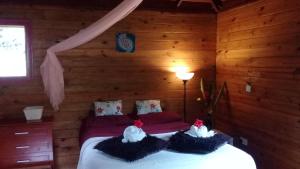 um quarto com uma cama num chalé de madeira em 3 Rivers Eco Lodge em Rosalie