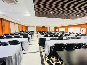 una sala de conferencias con mesas blancas y sillas negras en Hotel Amirana, en Chimoio