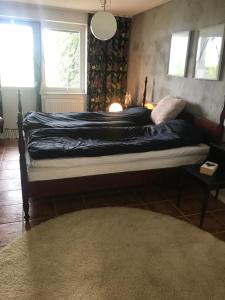 1 dormitorio con 1 cama con edredón negro en 3-rumslägenhet i villa med havsutsikt i Båstad Hindbärsvägen 22, en Båstad