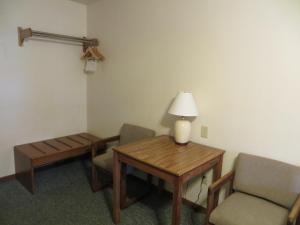 een kamer met een tafel en stoelen en een lamp bij Chief Motel in Custer