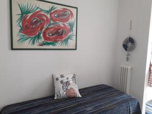 a bed with a pillow and a picture on the wall at Casa in SALENTO a Otranto in Otranto