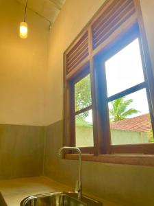 uma cozinha com um lavatório e uma janela em ALOHA Second Home em Tangalle