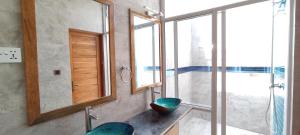 a bathroom with a shower and a sink with a mirror at Island Life Maldives Retreat & Spa in Magoodhoo